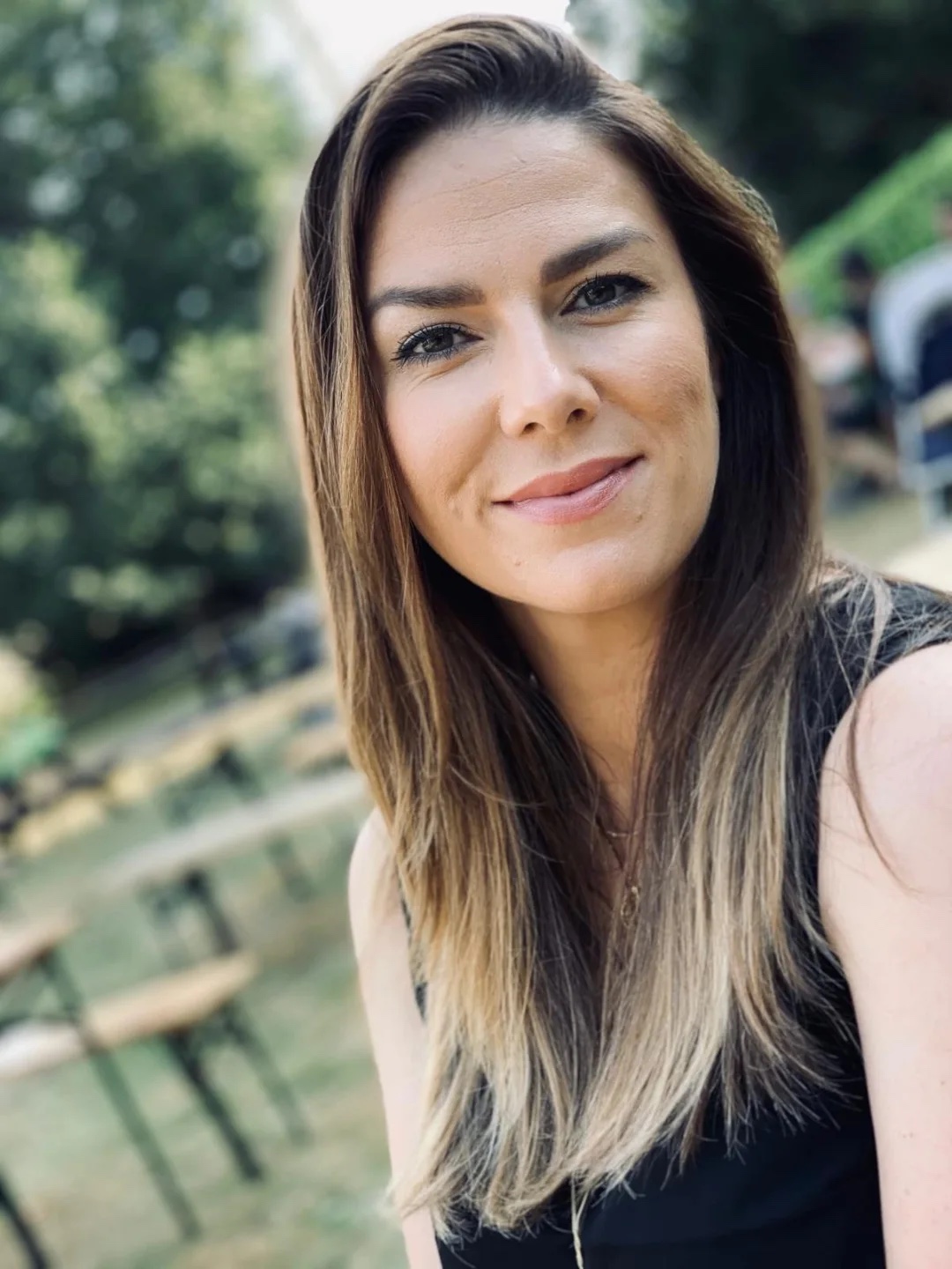 Laura, smiling, outdoors in soft light